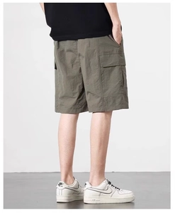 Detailed view of the side cargo pocket and quick-dry fabric on men's green utility shorts
