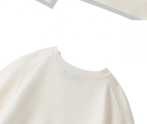 Detailansicht des V-Ausschnitts mit Rippenmuster an einem cremefarbenen Herrenstrickpullover