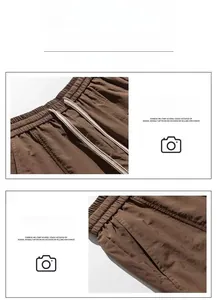 Detail view of elastic waistband and slanted front pockets on brown tech cargo shorts