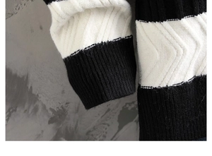 Details des schwarz-weiß gestreiften Strickpullovers mit strukturierten Rippbündchen