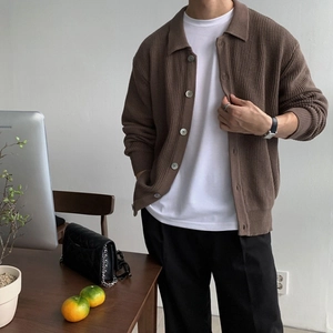 Detail der dunkelbraunen Strickjacke mit Reverskragen und feiner vertikaler Strickstruktur
