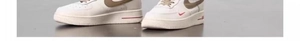 Detailed close-up of white leather sneakers featuring beige accents and red AIR branding
