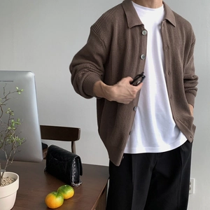 Makrodetail der braunen Strickjacke mit Polokragen und grauen runden Knöpfen