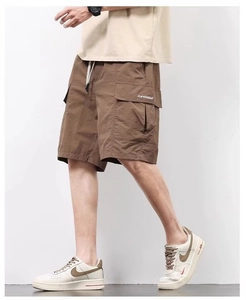 Detail of khaki cargo shorts showing the elastic drawstring waist and side flap pocket