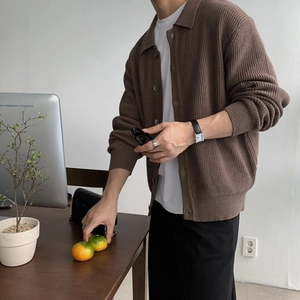 Detailansicht der braunen gerippten Strickjacke mit Polokragen und farblich passenden Knöpfen