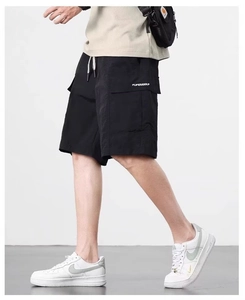 Detail of black cargo shorts featuring side flap pocket with white branding and drawstring