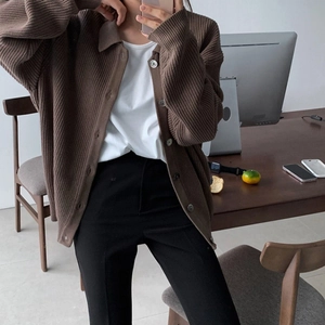 Detailaufnahme der braunen Strickjacke mit Kragen und Knöpfen am weiblichen Model