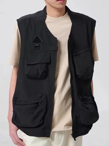 Close-up of black tactical utility vest with functional multi-pockets and zippered front