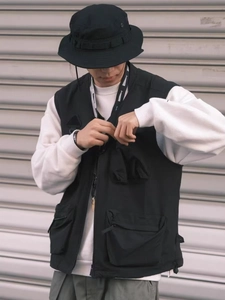 Detail of black tactical utility vest with multi-pocket design in urban outdoor style