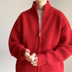 Detail der roten Strickjacke mit grober Textur und hochwertigem Metallreißverschluss