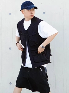 Detail of a black multi-pocket cargo vest with functional V-neck and D-ring styling