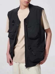 Detail of black tactical utility vest featuring multi-pocket design and water-resistant fabric