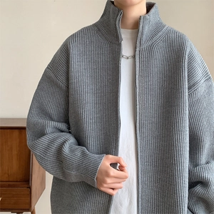 Detailaufnahme der grauen Strickjacke mit Stehkragen, Reißverschluss und Streifenmuster