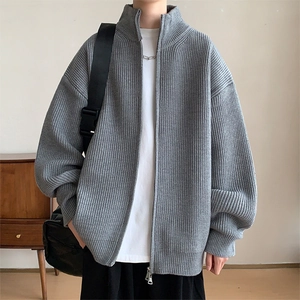 Detailaufnahme der grauen Strickjacke mit vertikaler Rippstruktur und silbernem Reißverschluss