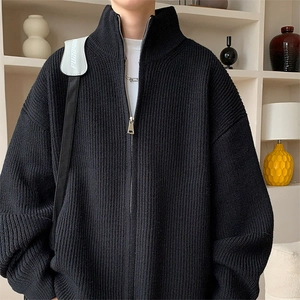 Detail einer schwarzen Strickjacke mit Stehkragen und silbernem Metallreißverschluss
