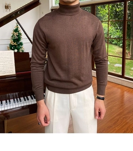 Schmal geschnittener, dunkelbrauner Rollkragenpullover für Herren mit weißer Hose in Wohnambiente