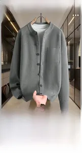 Gros plan sur cardigan gris avec texture côtelée verticale et boutons vert foncé