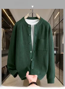 Détail du cardigan en maille vert foncé avec col rond et poche plaquée sur la poitrine