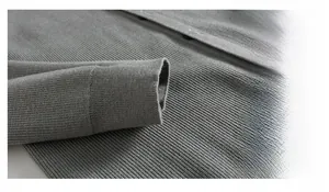 Détail du poignet d'un cardigan gris foncé montrant la texture fine en maille côtelée