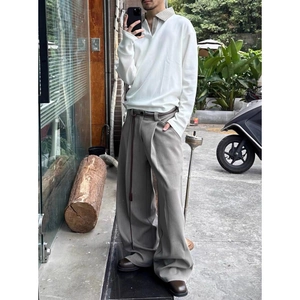 Polo da uomo bianca con colletto a quadri e pantaloni larghi grigi in stile casual chic