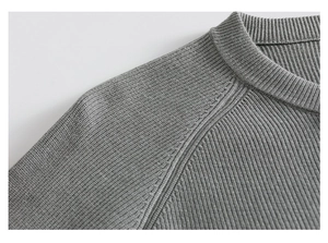 Gros plan sur les coutures du col rond et la maille fine du cardigan gris pour homme