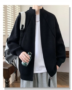 Dettaglio del cardigan in maglia nera ad alta densità con collo alto a zip e trama morbida