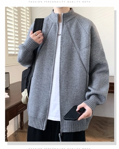 Dettaglio ravvicinato del cardigan grigio con trama ad alta densità e cuciture a V sul petto