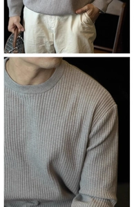 Detail view of light grey ribbed knit sweater with a classic crew neck and premium texture