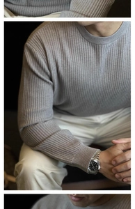Detail of grey ribbed knit long sleeve sweater featuring vertical stripes and crew neck