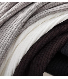 Detail shot of ribbed knit fabric texture in grey, white, coffee, and black tones