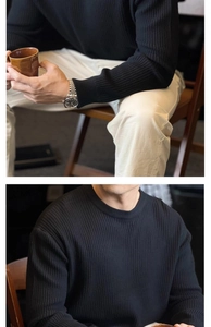 Detail showing black ribbed knit texture on men's round neck sweater and sleeve cuff