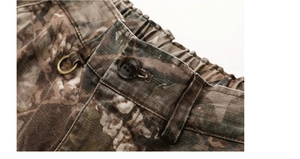 Dettaglio dei pantaloni cargo mimetici con vita elastica, bottone in resina e anello a D in metallo