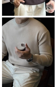 Close-up of ribbed knit texture on a men's off-white crewneck sweater with long sleeves