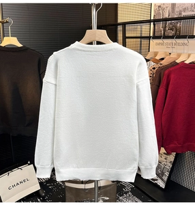 Détail d'un pull en maille blanc avec col rond et bords-côtes aux poignets, vue de dos
