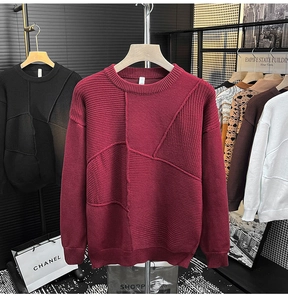 Détail d'un pull bordeaux à col rond montrant des motifs en maille asymétriques et bords-côtes