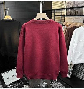 Détail du pull en maille bordeaux à col rond avec poignets côtelés dans une boutique