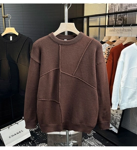 Détail d'un pull en maille marron foncé avec patchwork texturé et col rond côtelé
