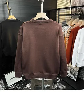 Détail du pull en tricot marron montrant les poignets côtelés et la texture fine