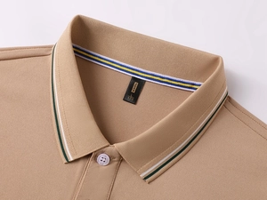Detailed close-up of khaki pique polo shirt collar with green stripes and fashion label