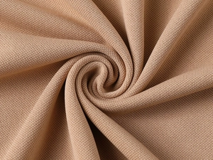 Close-up of khaki piqué polo shirt fabric texture with soft folds and breathable knit detail