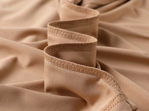 Macro shot of breathable khaki mesh knit fabric with professional overlock seam detail