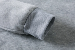 Close-up of the ribbed cuff detail and knitted fabric texture on a gray hooded sweatshirt