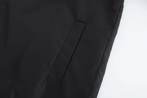 Detail view of the reinforced side pocket stitching on a black hooded casual jacket