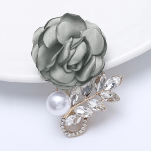 Macro detail of elegant grey satin fabric flower brooch with pearls and rhinestones