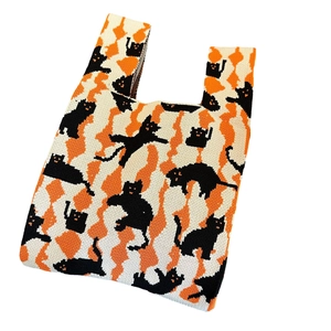 Knitted tote bag featuring orange and black Halloween cat pattern on white background