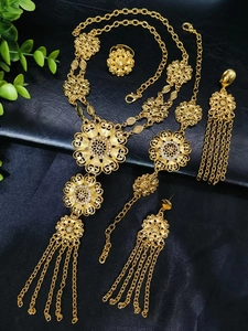 Detailed view of 24k gold jewelry set with flower patterns and delicate tassels