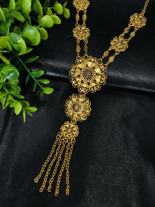 Close-up of a 24k gold-plated bridal necklace with tiered floral pendants and gold tassels