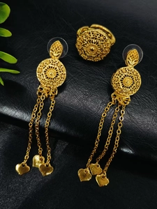 Detail of 24k gold jewelry set featuring filigree earrings with tassel and leaf pendants