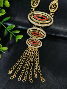 Detailed close-up of 24k gold plated necklace with red rhinestones and elegant tassels
