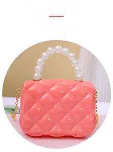 Detail of mini bright pink jelly bag with quilted pattern and pearl handle with gold chain